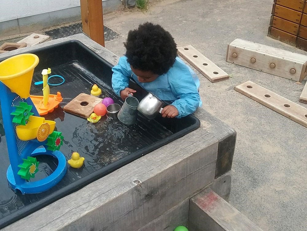 cute baby playing with toys in water at a Montessori Pre-school and Nursery Serving Colindale, Edgware & St Albans UK