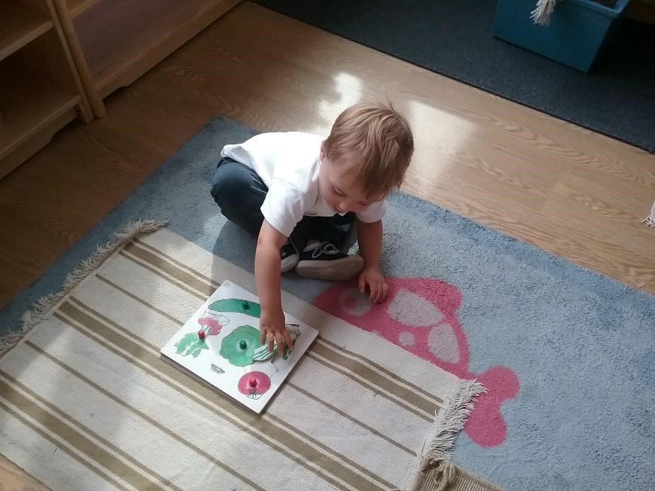 cute toddler playing on the floor at a Montessori Pre-school and Nursery Serving Colindale, Edgware & St Albans UK