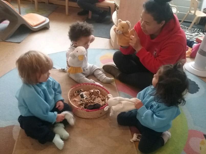 teacher and babies playing with hand puppet at a Montessori Pre-school and Nursery Serving Colindale, Edgware & St Albans UK