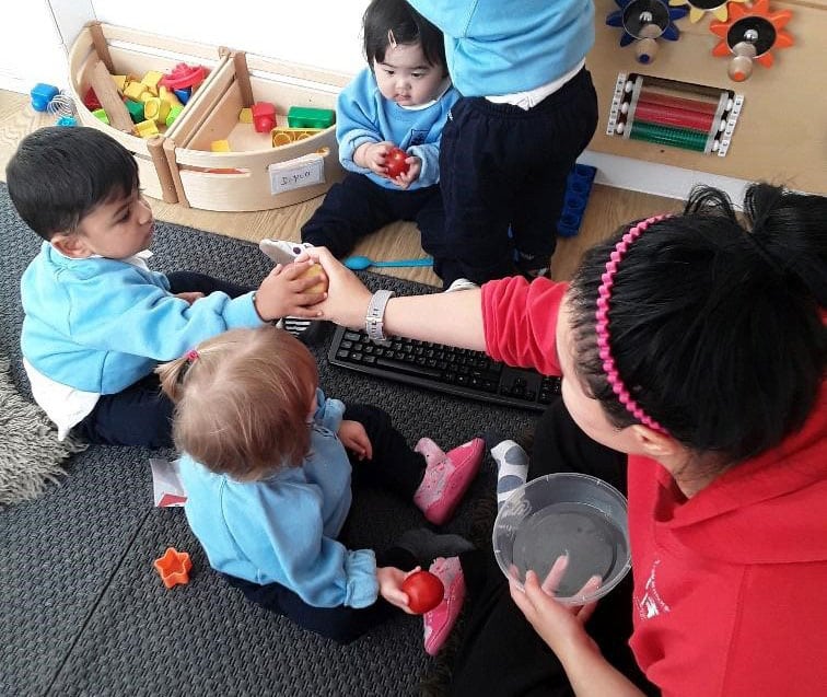 teacher and babies playing with toys at a Montessori Pre-school and Nursery Serving Colindale, Edgware & St Albans UK